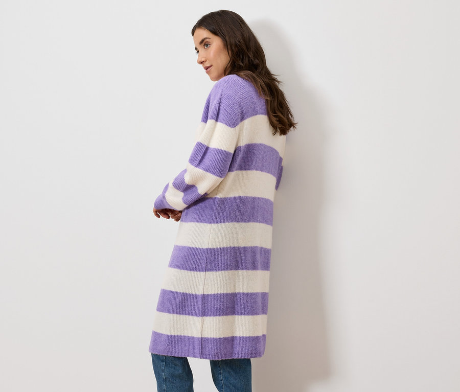 Frau posiert in einem langen, gestreiften Cardigan in Lila und Creme.
