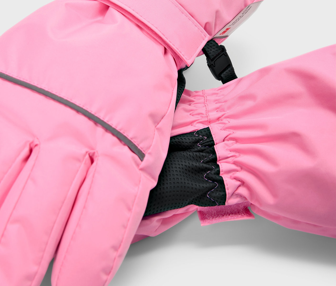 Detailaufnahme von rosafarbenen Kinder-Skihandschuhen mit schwarzem Innenbündchen.
