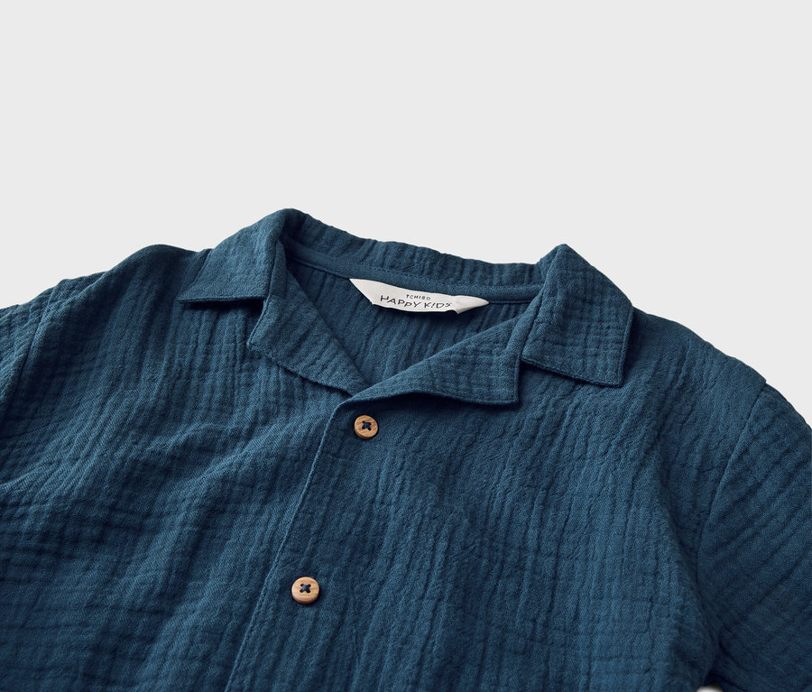 Nahaufnahme eines dunkelblauen Hemdes mit Kragen und Knöpfen.