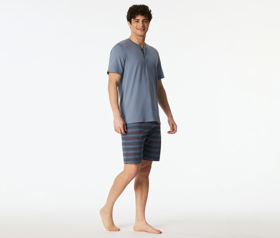 Mann trägt einen blauen T-Shirt- und Shorts-Pyjama mit Streifen.