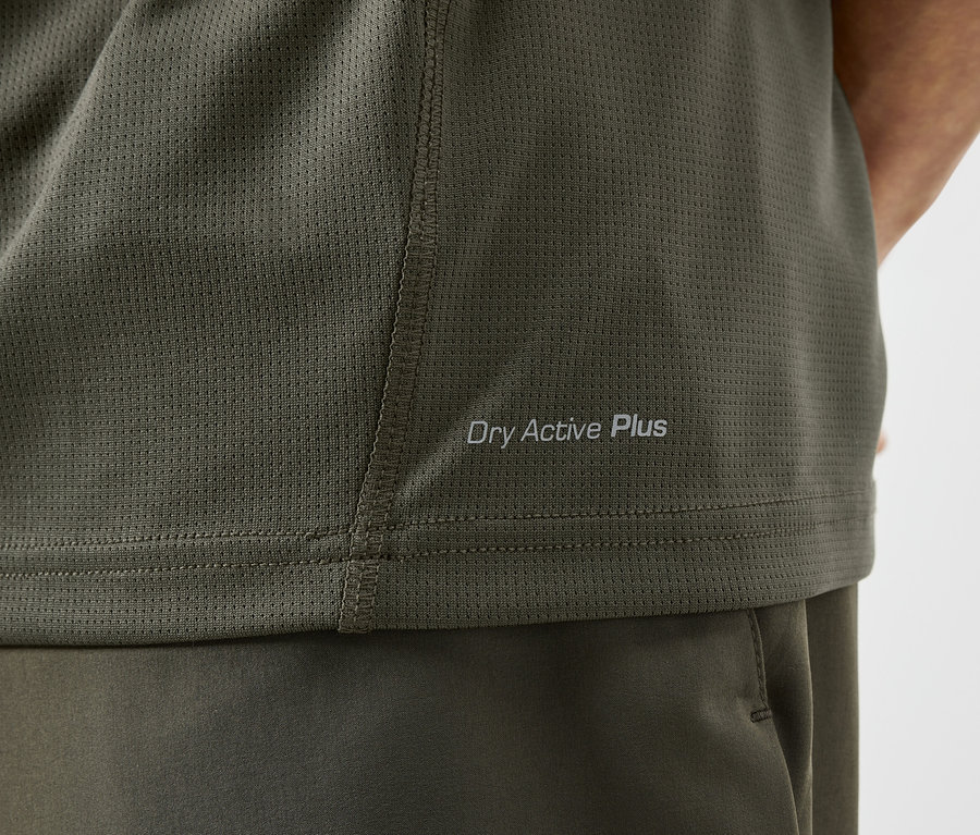 Nahaufnahme eines olivgrünen Sportshirts mit der Aufschrift "Dry Active Plus".