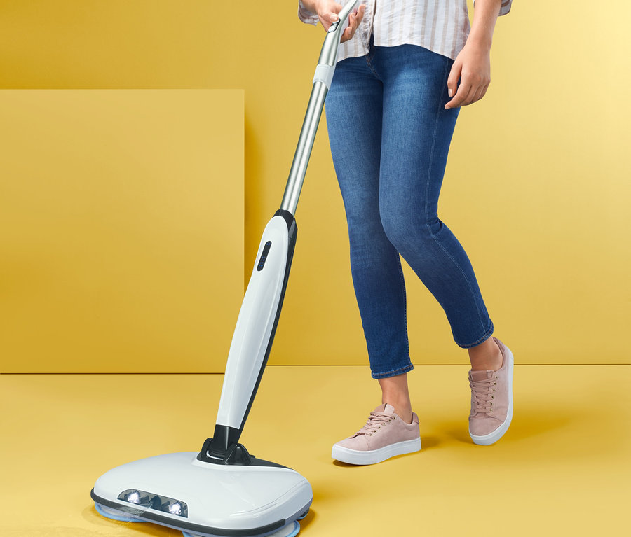 Frau wischt den Boden mit einem elektrischen Bodenwischer.