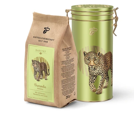 Eine braune Kaffeetüte und eine grüne Kaffeedose mit einem Leoparden darauf stehen nebeneinander.