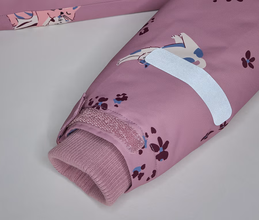 Nahaufnahme eines rosa Ärmels mit Katzenmuster, einem reflektierenden Streifen und einem gerippten Bündchen.