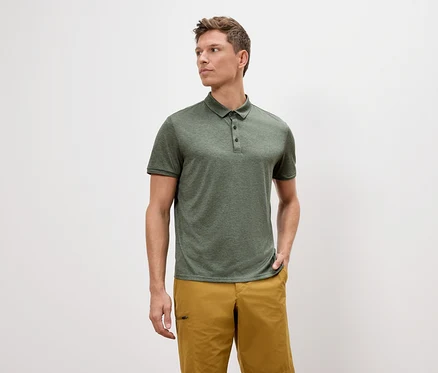 Mann trägt ein grünes Polohemd und goldene Shorts.