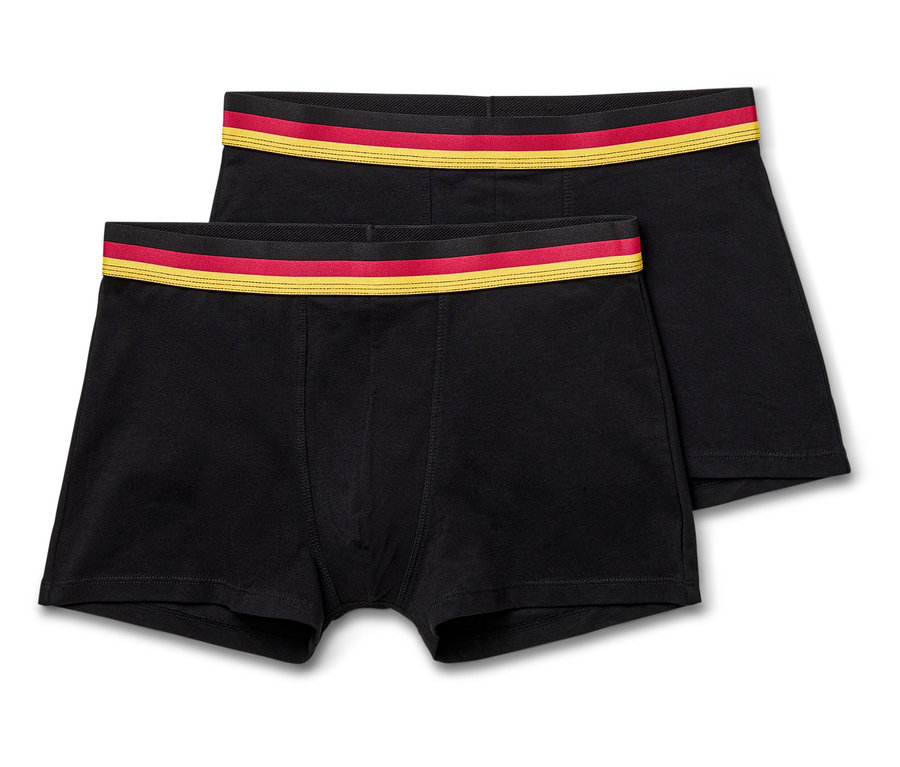 Zwei schwarze Boxershorts liegen übereinander, mit einem rot-goldenen Bund.