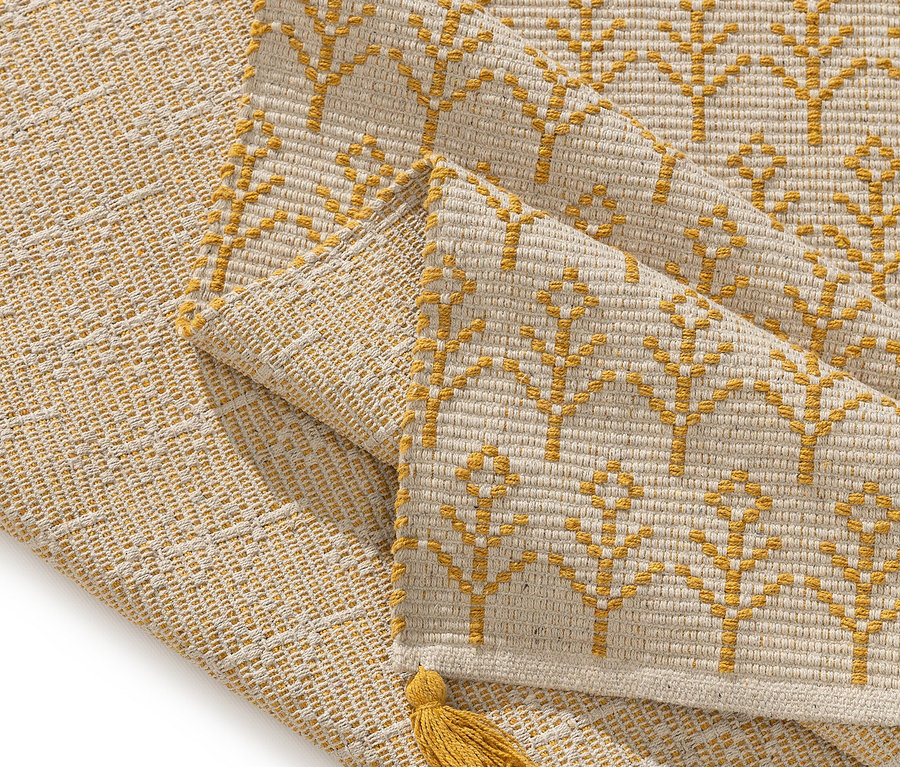 Nahaufnahme eines beige-goldenen Tischläufers mit Quaste.