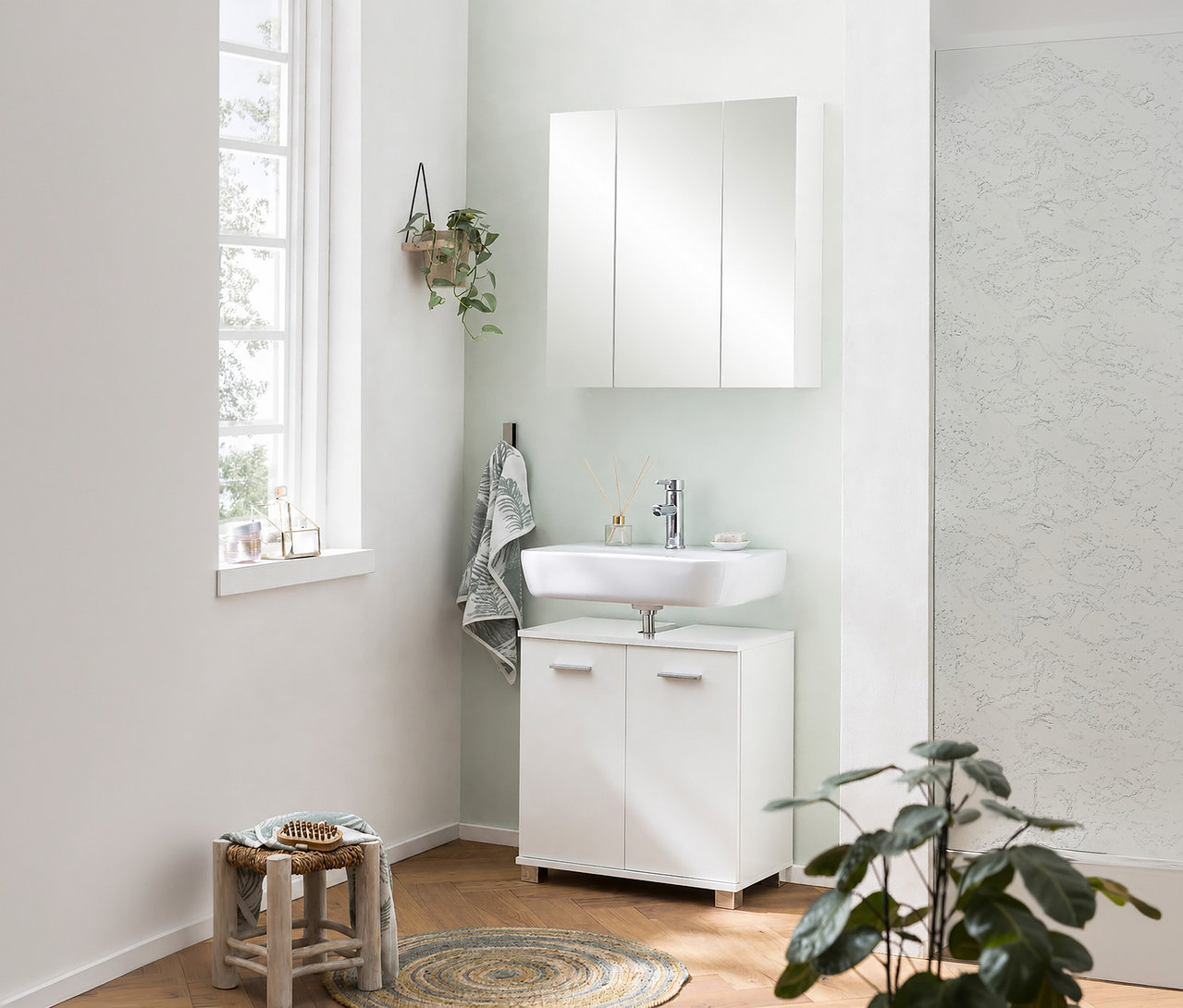 Helles Badezimmer mit einem weißen Spiegelschrank »Basic«, 70 cm, über einem Waschbecken mit Unterschrank, daneben ein Fenster.