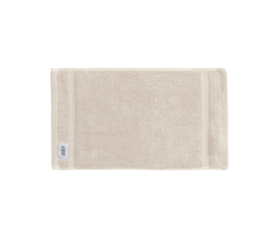 Sandfarbenes Gästehandtuch der SCHÖNER WOHNEN-Kollektion "Cuddly" mit Markenetikett.