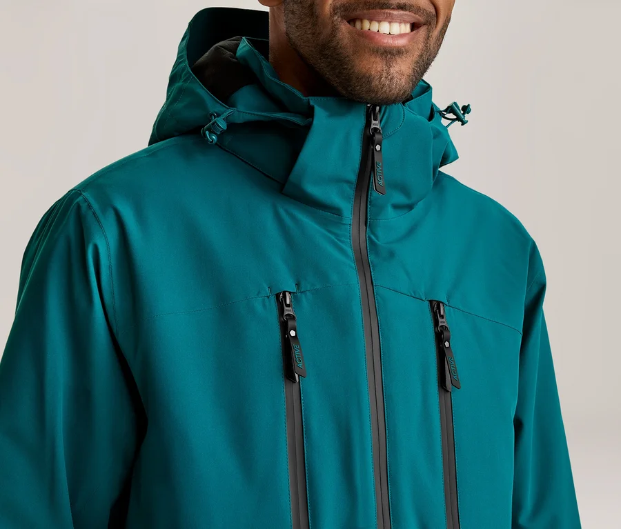 Lächelnder Mann in einer türkisfarbenen Kapuzenjacke mit Reißverschluss und zwei Brusttaschen.