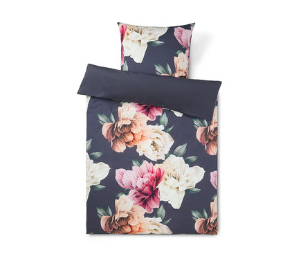 Bettwäsche-Set mit dunkelblauem Hintergrund und großem Blumenmuster aus rosa, pfirsichfarbenen und cremefarbenen Blüten mit grünen Blättern. Der Bettbezug ist gefaltet und zeigt eine einfarbige dunkelblaue Unterseite, darüber liegt ein passender Kissenbezug.