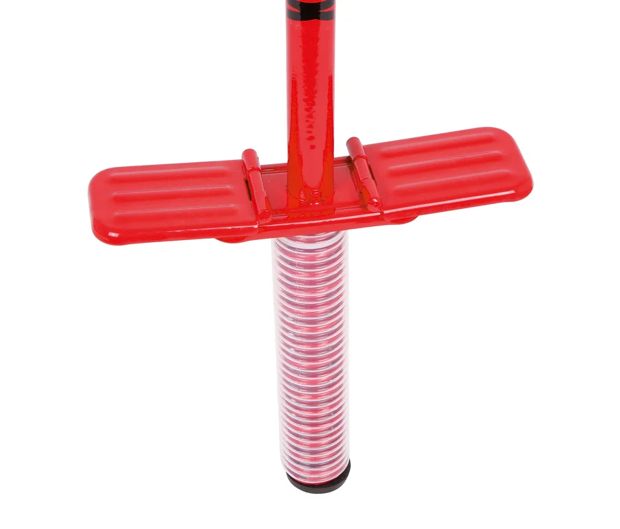 Nahaufnahme eines roten Pogo-Sticks, der die gerippten Fußstützen zeigt, die horizontal vom Hauptschaft abstehen, über einem durchsichtigen Rohr, das eine rot-silberne Feder enthüllt.