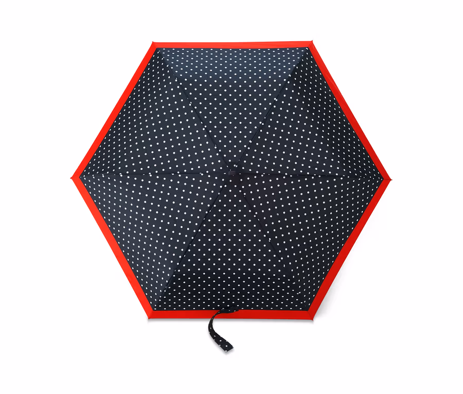 Nahaufnahme eines Taschenschirms mit dunkelblauem Hintergrund und weißen Punkten, eingefasst in Rot.