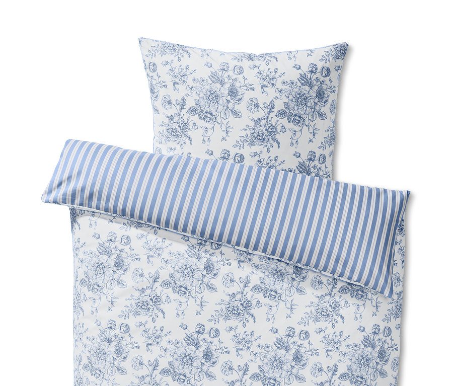 Weiße Renforcé-Wendebettwäsche in Doppelgröße mit Blumenmuster und blau gestreiftem Saum.