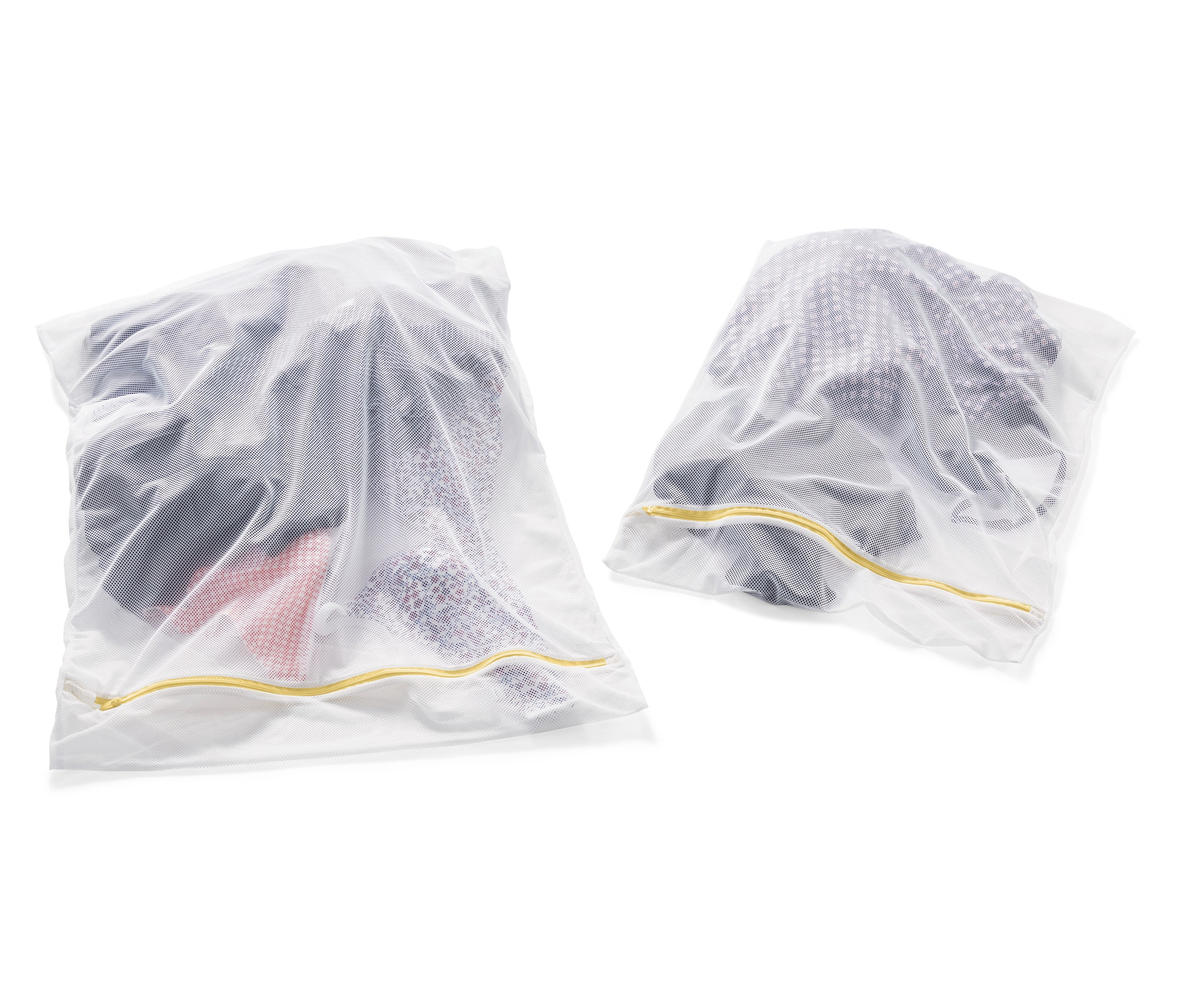 Zwei weisse XL-Wäschenetze gefüllt mit Kleidung.