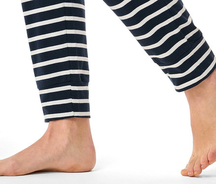 Beine einer Person in dunkelblauen, gestreiften Hosen.