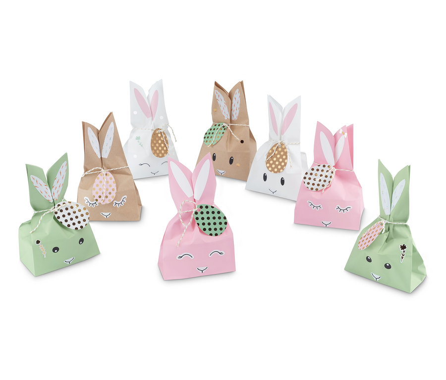 Sieben Osterhasen-Geschenktüten in Grün, Braun, Weiß und Rosa mit Hasengesicht und Ohren.