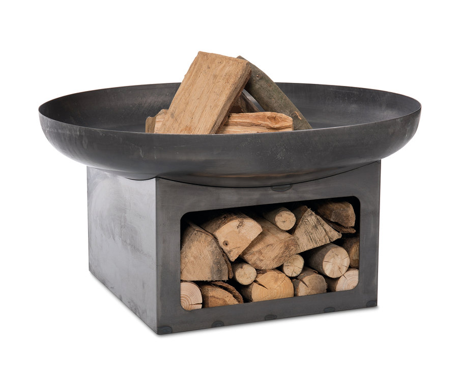 Die Feuerschale »Juva Industrial«, ca. 80 cm Durchmesser, ist mit Holz befüllt. Unterhalb der Schale befindet sich ein Fach, das ebenfalls mit Holzscheiten gefüllt ist.