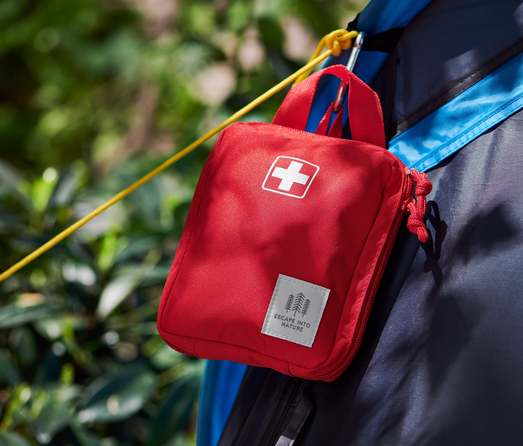 Eine rote Erste-Hilfe-Tasche hängt an einem Zelt.