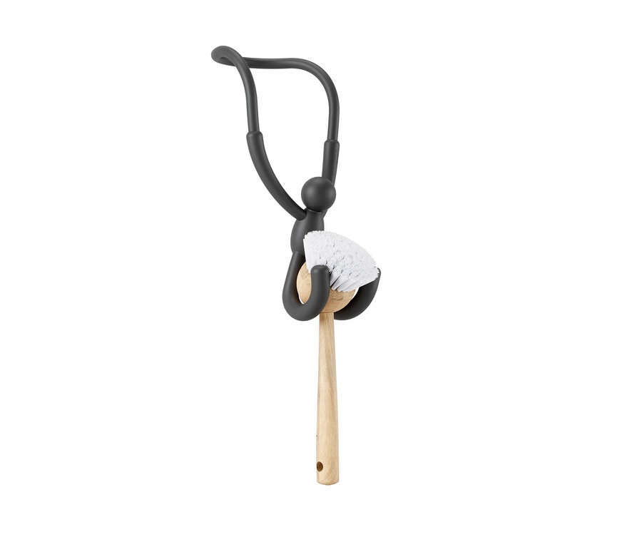 Eine schwarze Figur hält eine Spülbürste mit Holzgriff. Umbra-Spülbecken-Organizer »Buddy Flex«.