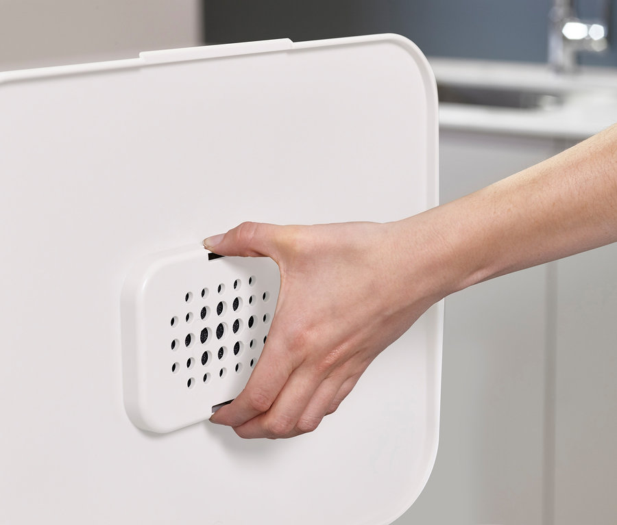 Eine Hand hält einen weißen Filter des Recycling-Abfalleimers, Joseph Joseph.