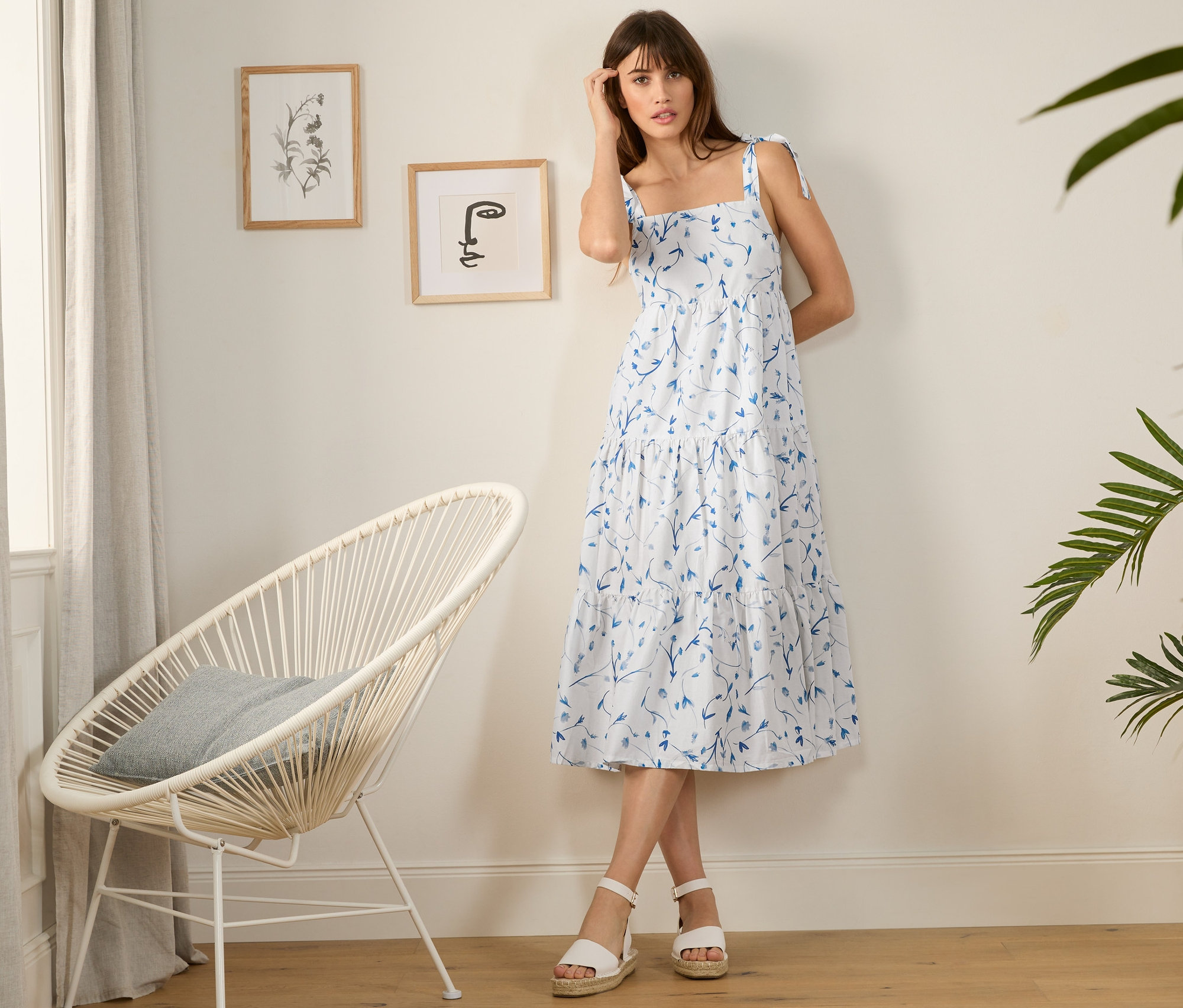 Frau steht und trägt ein bedrucktes Webkleid.