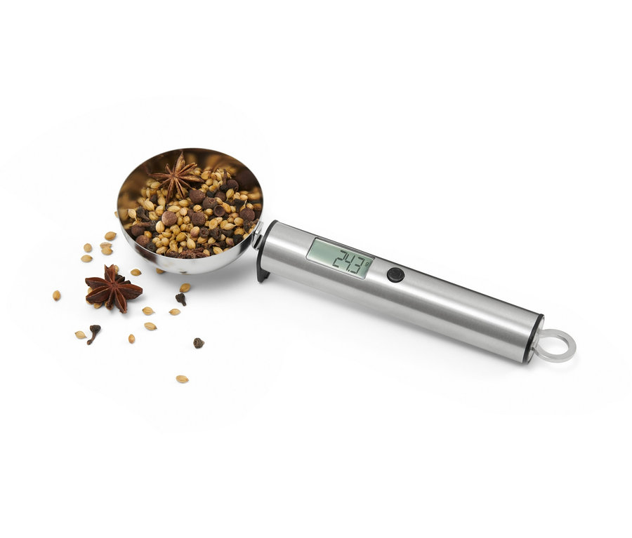 Eine digitale Löffelwaage gefüllt mit Gewürzen.