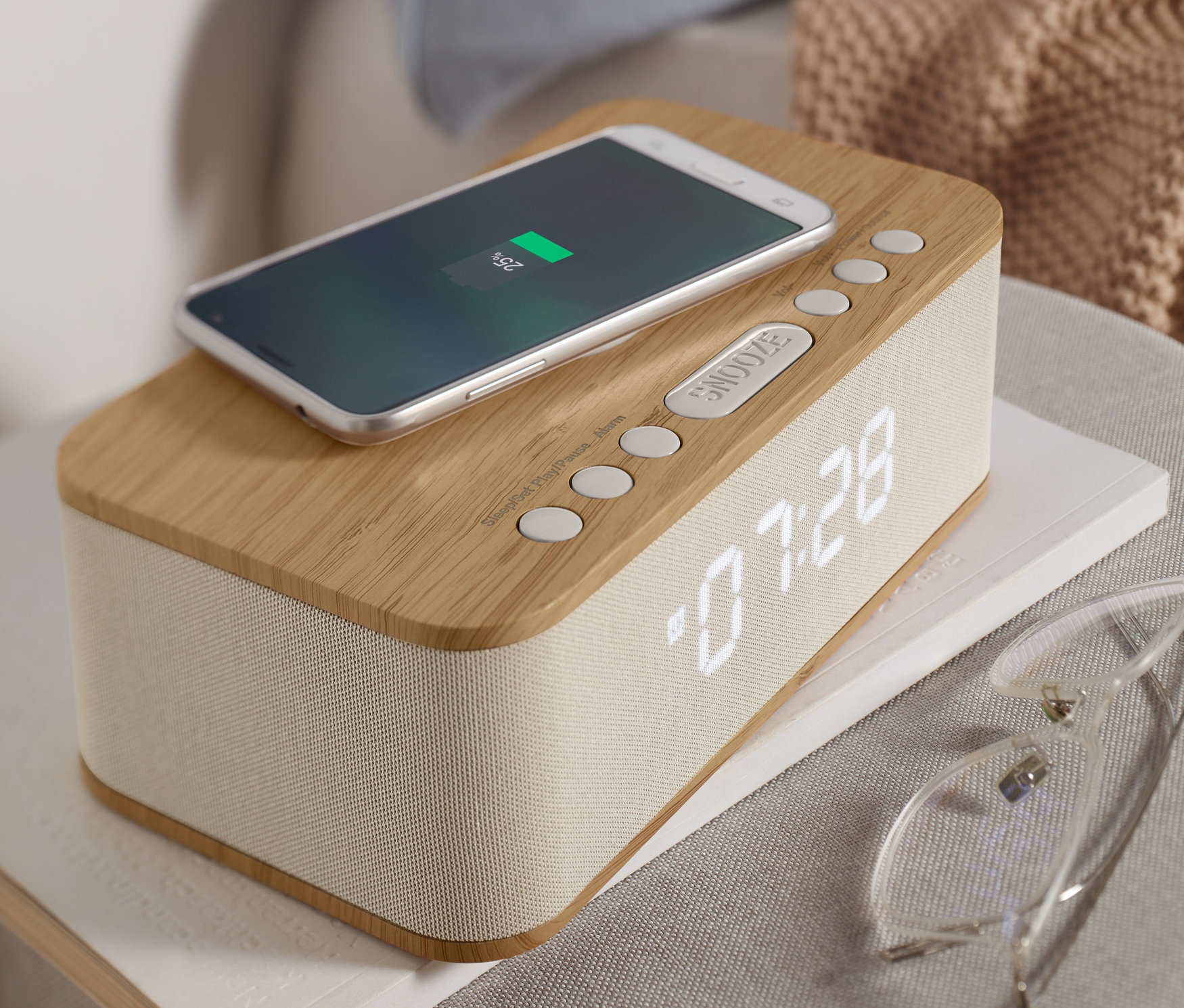 Handy lädt auf Bluetooth-Wecker mit kabelloser Ladefunktion.