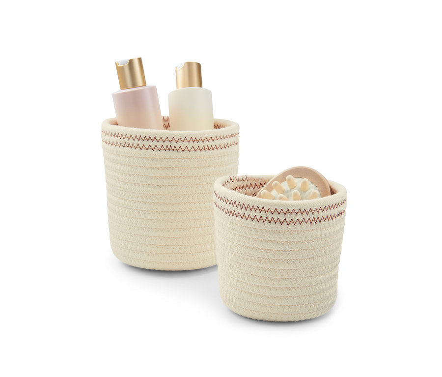 Zwei crèmeweiß-rostfarbene Aufbewahrungskörbe, einer mit zwei Flaschen.