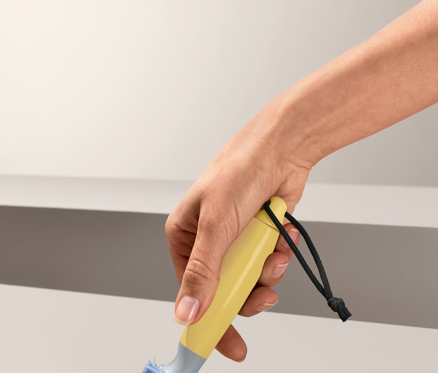 Eine Hand hält eine Universalreinigungsbürste und reinigt eine Oberfläche.