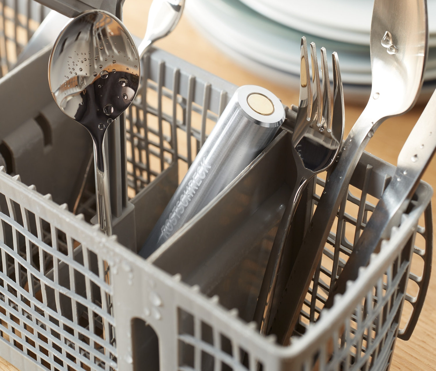 Silbernes Besteck in einem grauen Geschirrspülkorb mit Rostschreck für die Spülmaschine.