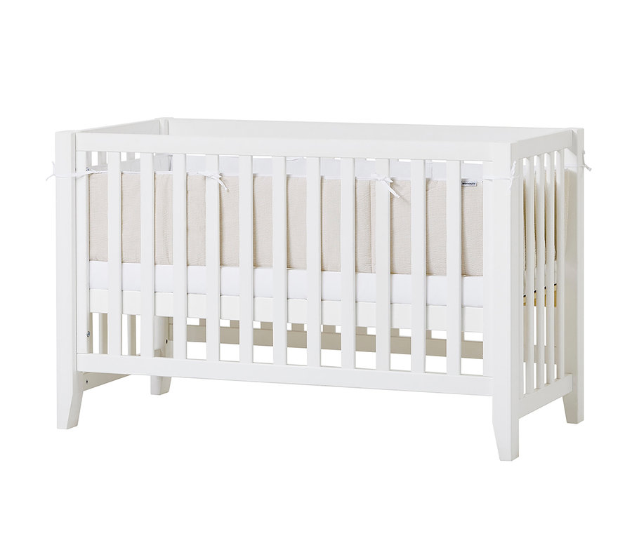 Ein weißes Hoppekids Babybett "Anton" mit beiger Einlage.