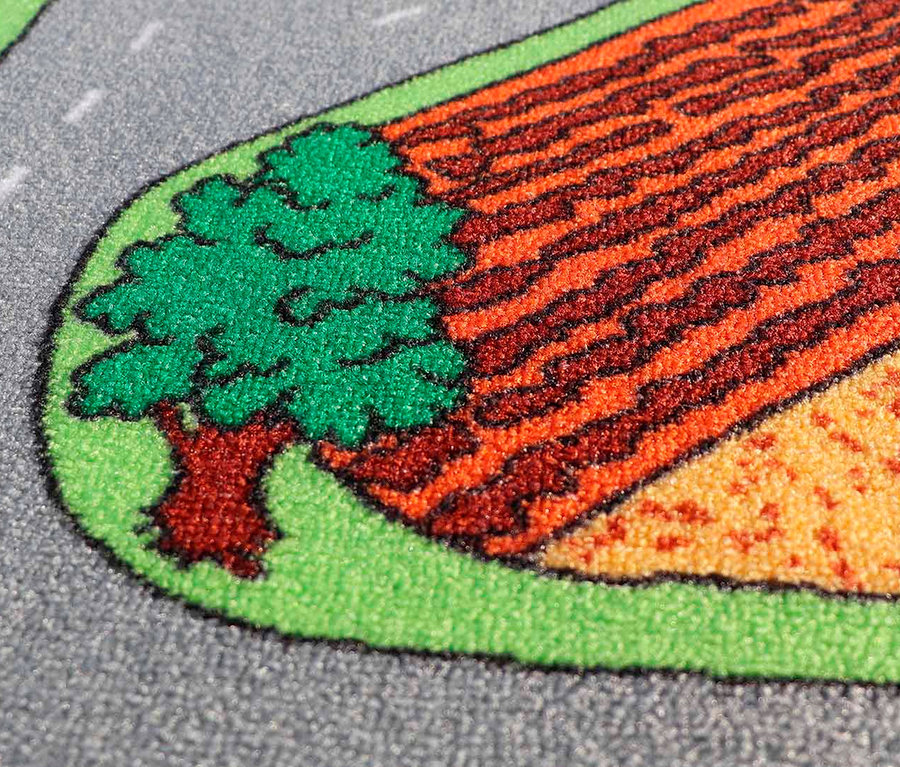 Detailaufnahme eines Teils eines Spielteppichs mit Bauernhofmotiv, Feld und Baum.