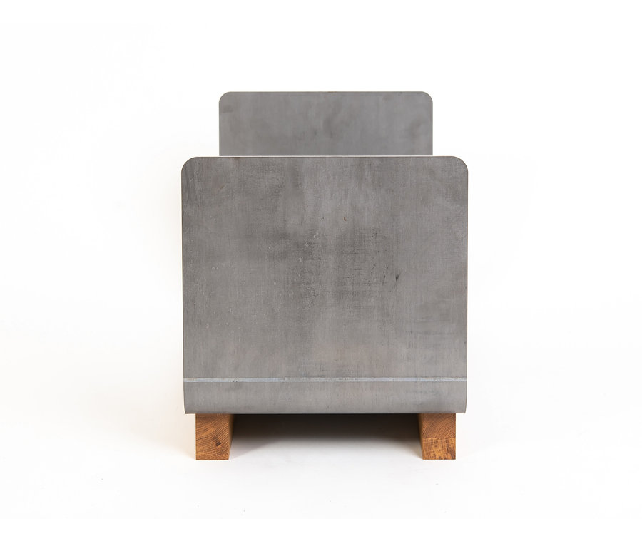 Ein Kaminholzregal aus Metall mit Holzsockel auf weißem Hintergrund.