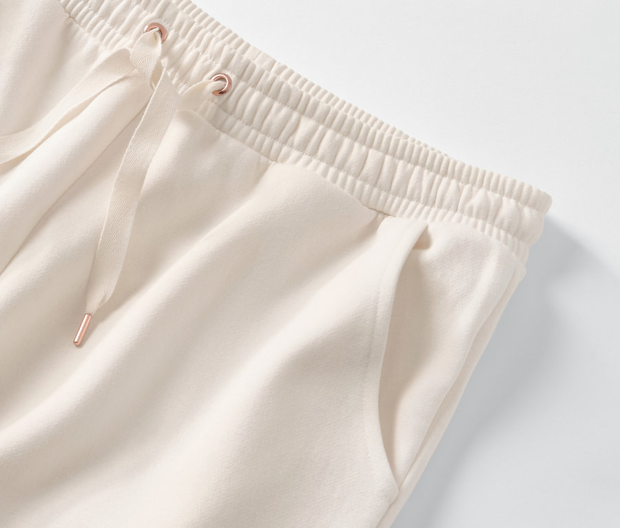 Detail einer cremefarbenen Hausanzughose mit elastischem Bund und Kordelzug.