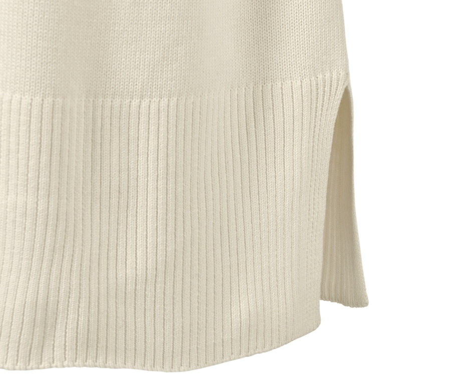 Detailansicht eines langen Strickpullovers in Cremeweiß.