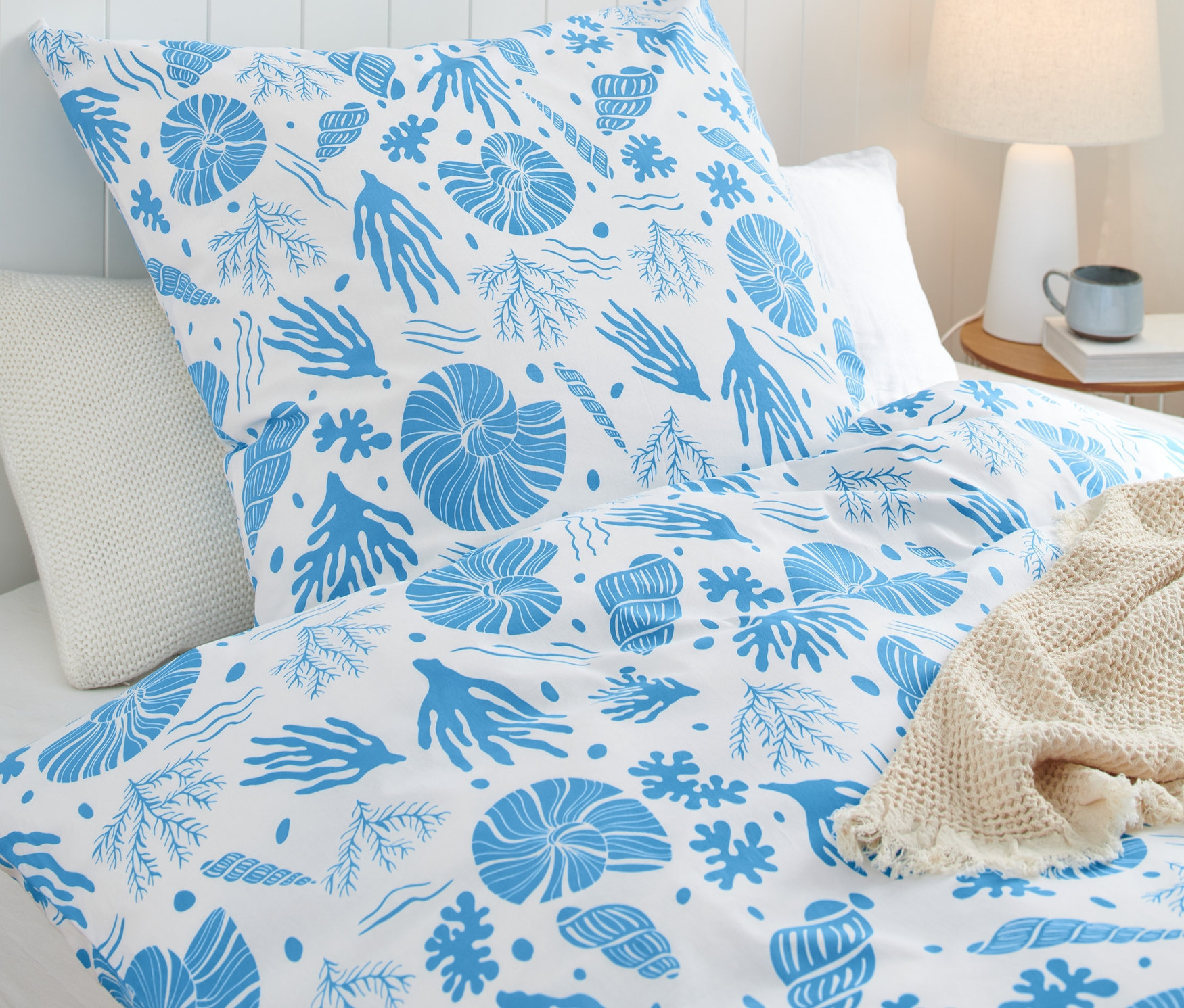 Renforcé-Bettwäsche in Normalgröße mit blauem Meeresmotiven-Muster auf einem Bett.