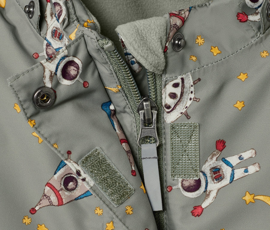 Detailansicht eines Kinder-Schneeanzugs mit Weltraum-Muster und offenem Reißverschluss.