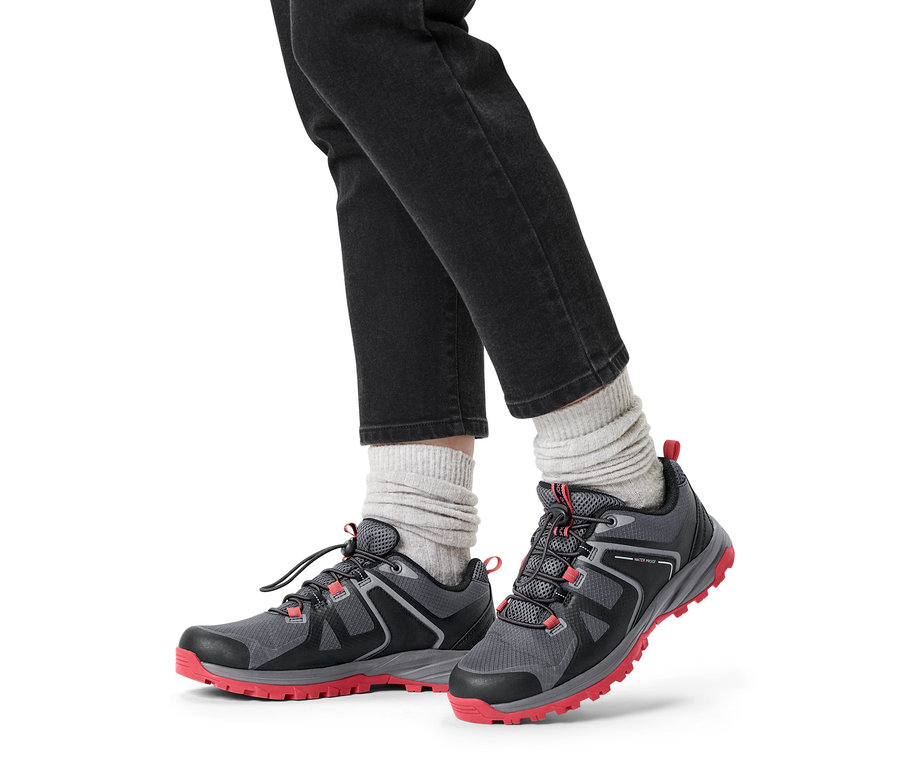 Beine in grauen Trekkingschuhen.