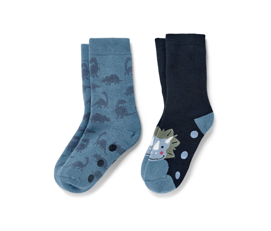 Zwei Paar Kinder-Antirutsch-Socken: ein blaues Paar mit Dinosauriern, ein marineblaues Paar mit Triceratops.