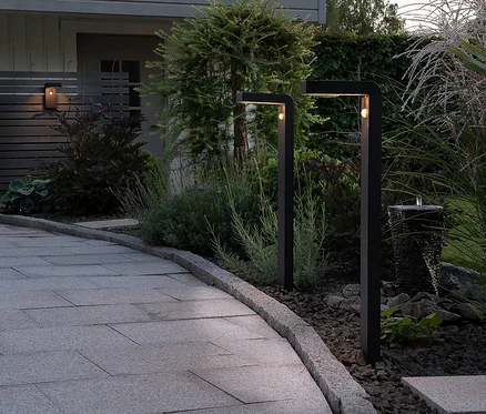 Zwei Eglo Solar-Stehleuchten »Baracconi« beleuchten einen Gartenweg.