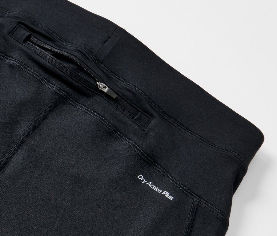 Detail einer schwarzen Lauftight mit Reissverschlusstasche und Dry Active Plus Schriftzug.