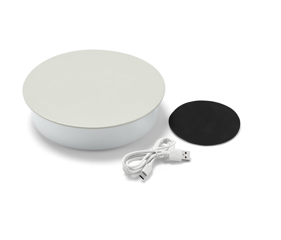 Eine weiße LED-Akku-Wandleuchte mit Ladekabel und schwarzem Magnet.