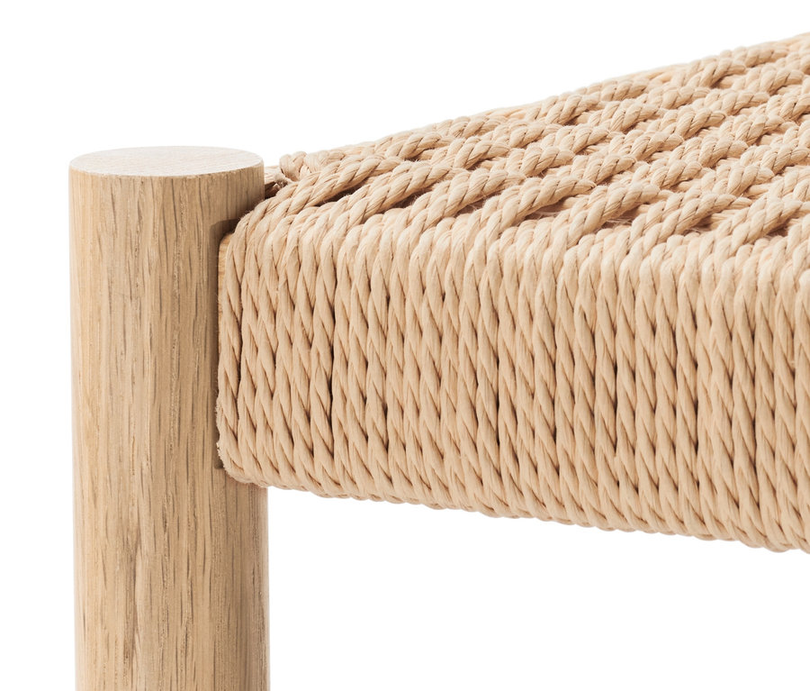 Detailaufnahme eines Holzschemels mit geflochtener Sitzfläche.