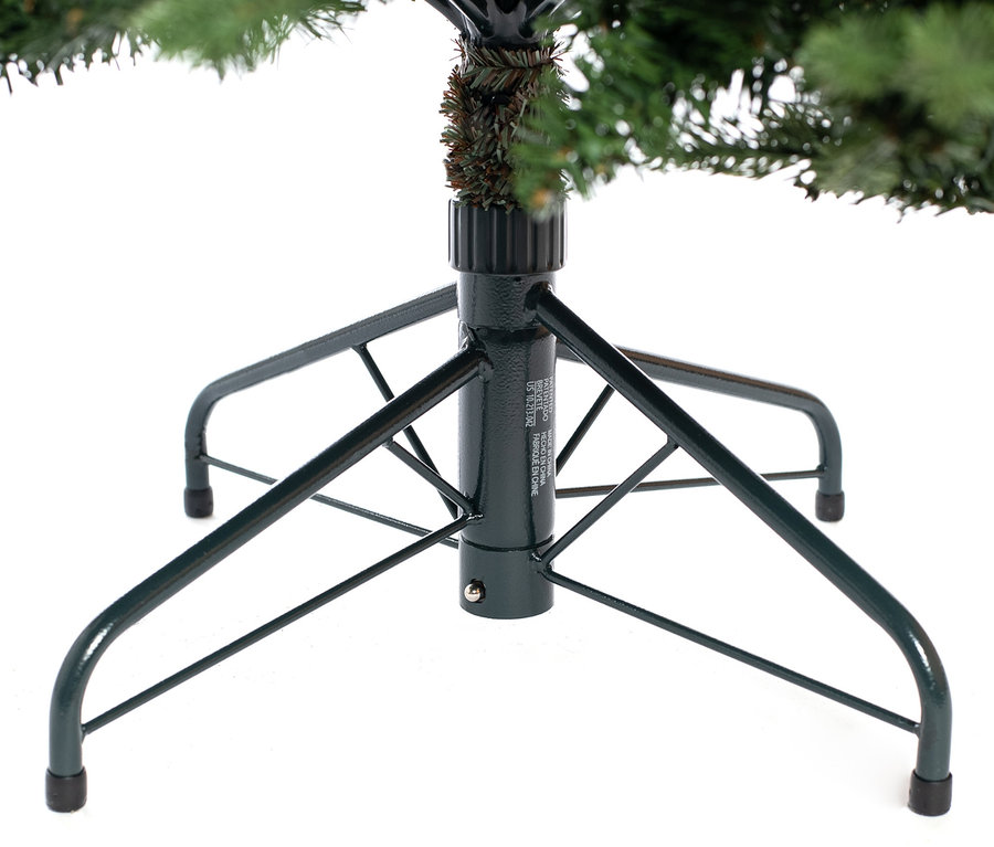 Ein grüner Metallständer hält einen künstlichen Weihnachtsbaum.