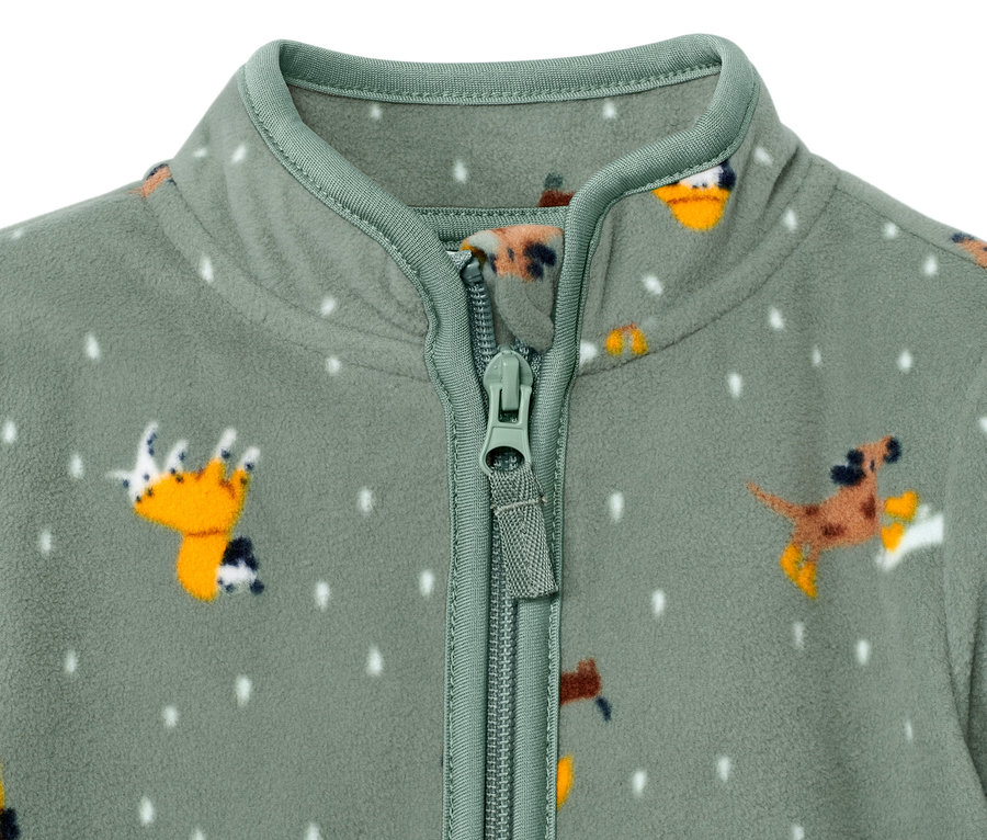 Detailansicht einer grünen Kinder-Fleecejacke mit Reißverschluss und Hundemuster.
