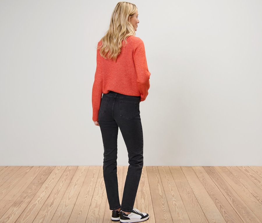 Blonde Frau posiert von hinten in orangefarbenem Pullover und Slim Jeans – Fit »Emma«.