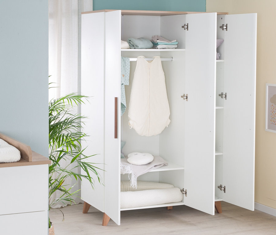 Geöffneter, weißer Kleiderschrank »Ole« mit braunen Details steht im Kinderzimmer.