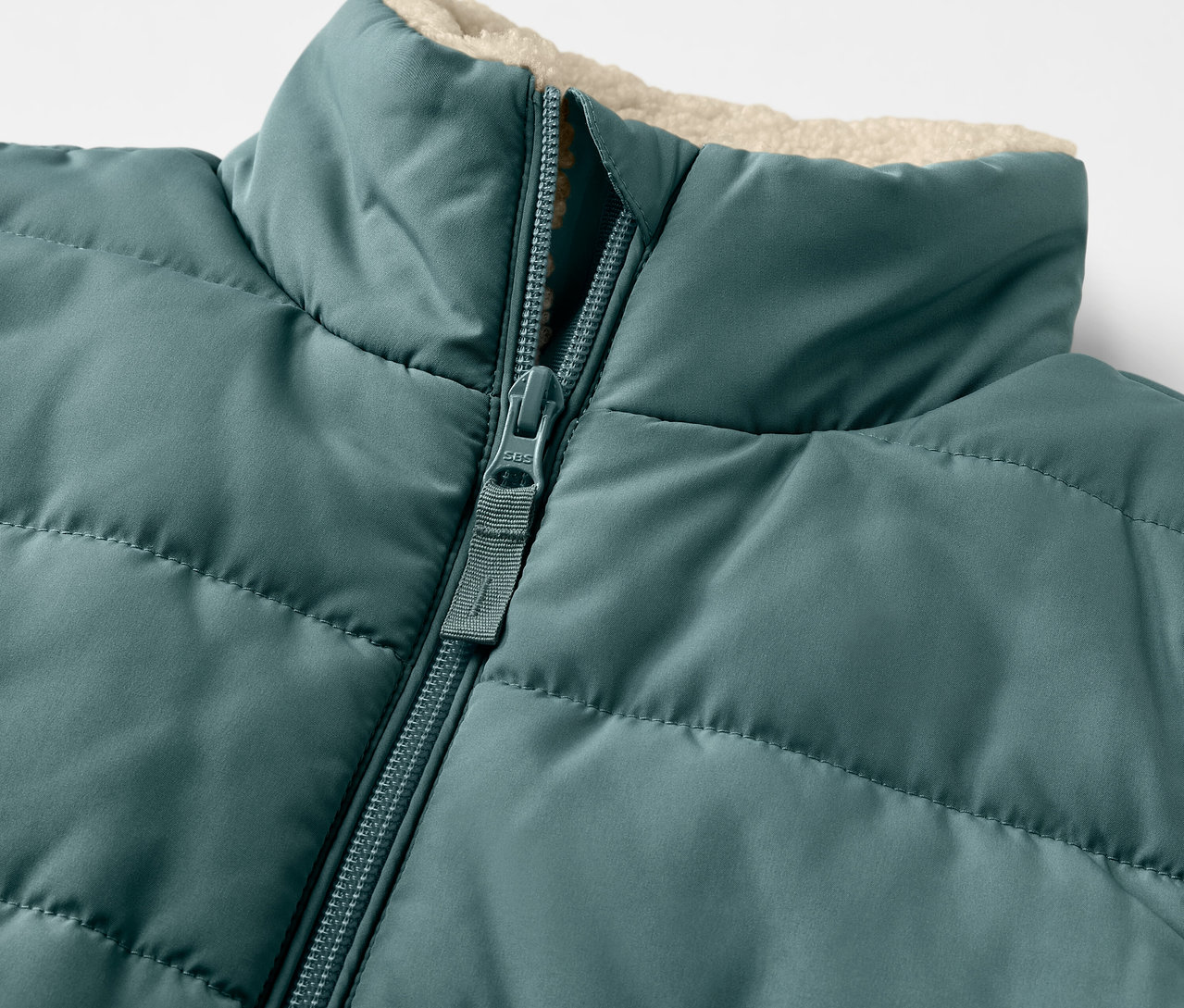 Detail einer Kinder-Teddyplüsch-Steppweste mit Reißverschluss.