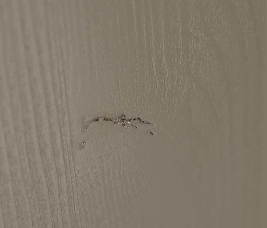 Detailaufnahme einer Beschädigung auf einer Holzoberfläche.